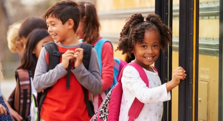 Kids by a school bus